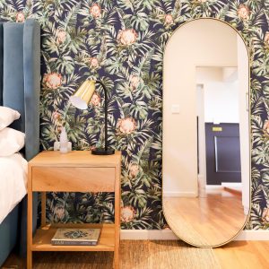 Aura Mirror Large in Gold styled as a leaning mirror in a bedroom setting